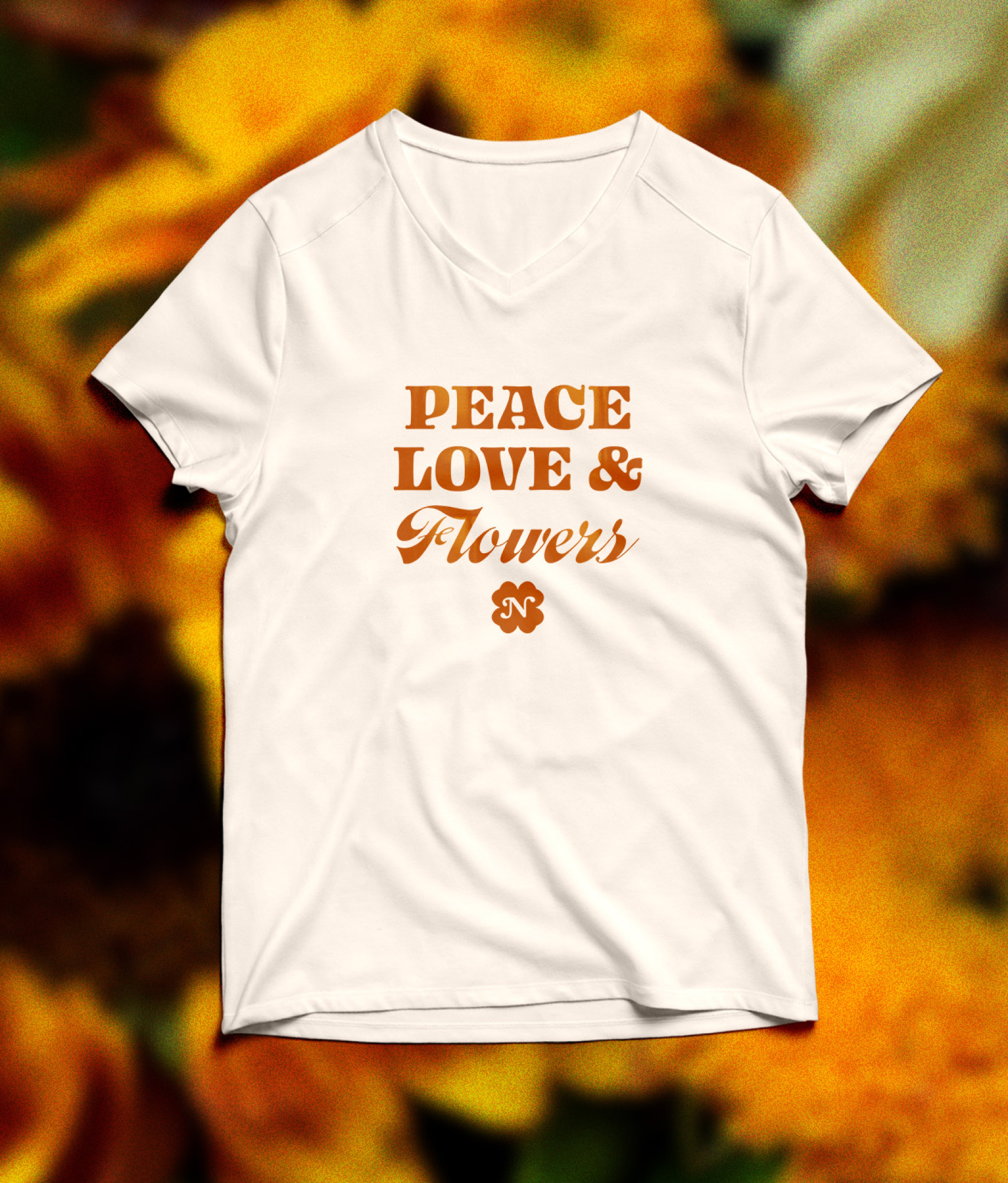 A white t-shirt printed with Peace, Love & Flowers above the clover monogram